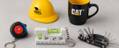Branded promotional merchandise for construction companies including a hard hat stress toy, tape measure keyring, spirit level keyring, multi tool and mug from Style Brands UK