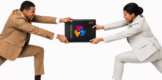 Two business people in suits pulling a branded 2027 desk diary in opposite directions in a tug of war